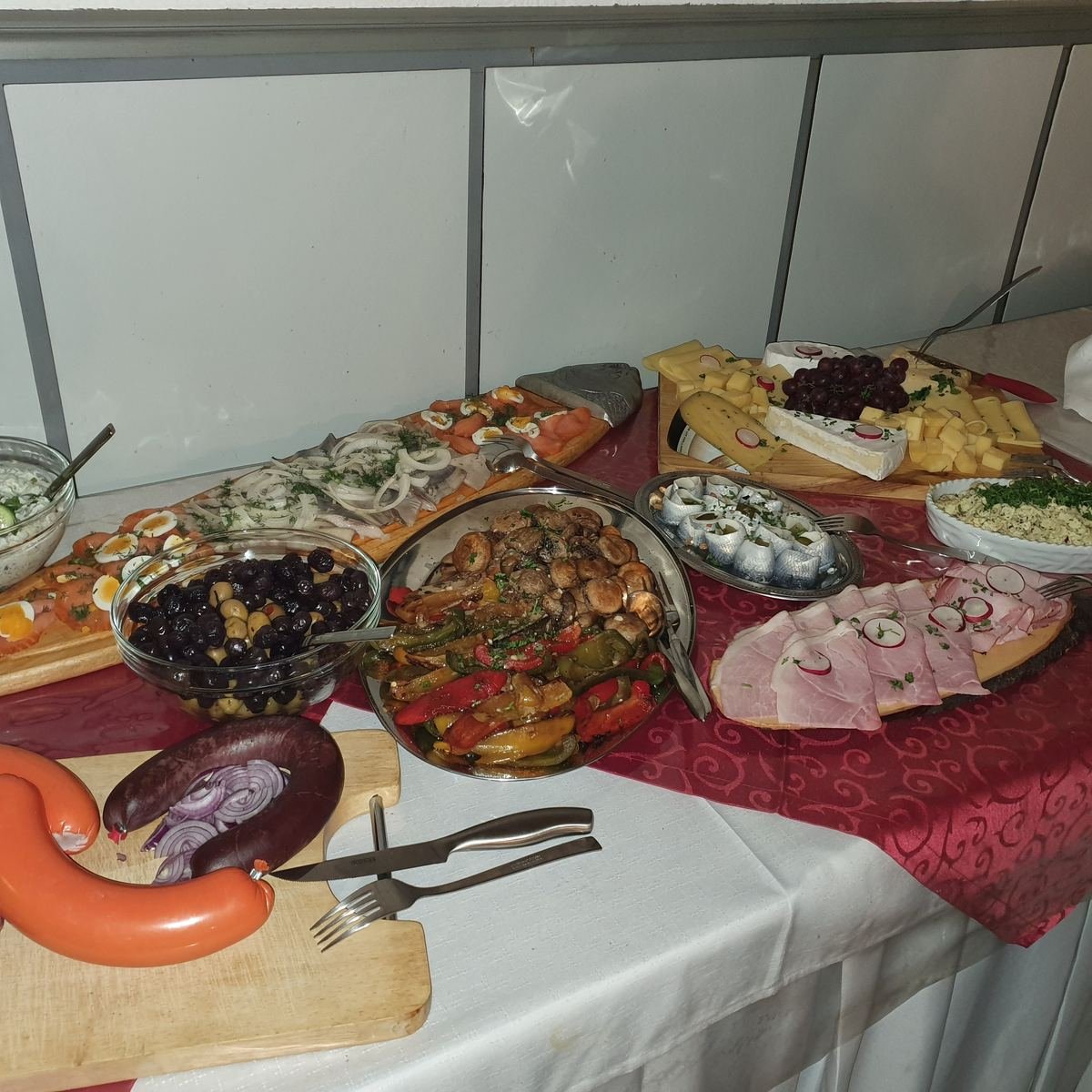 Kaltes Buffet: Fleischwurst, Oliven, gegrilltes Gemüse mit Champignons, Hering mit Zwiebeln, Lachs mit Ei, Käse und Schinken.