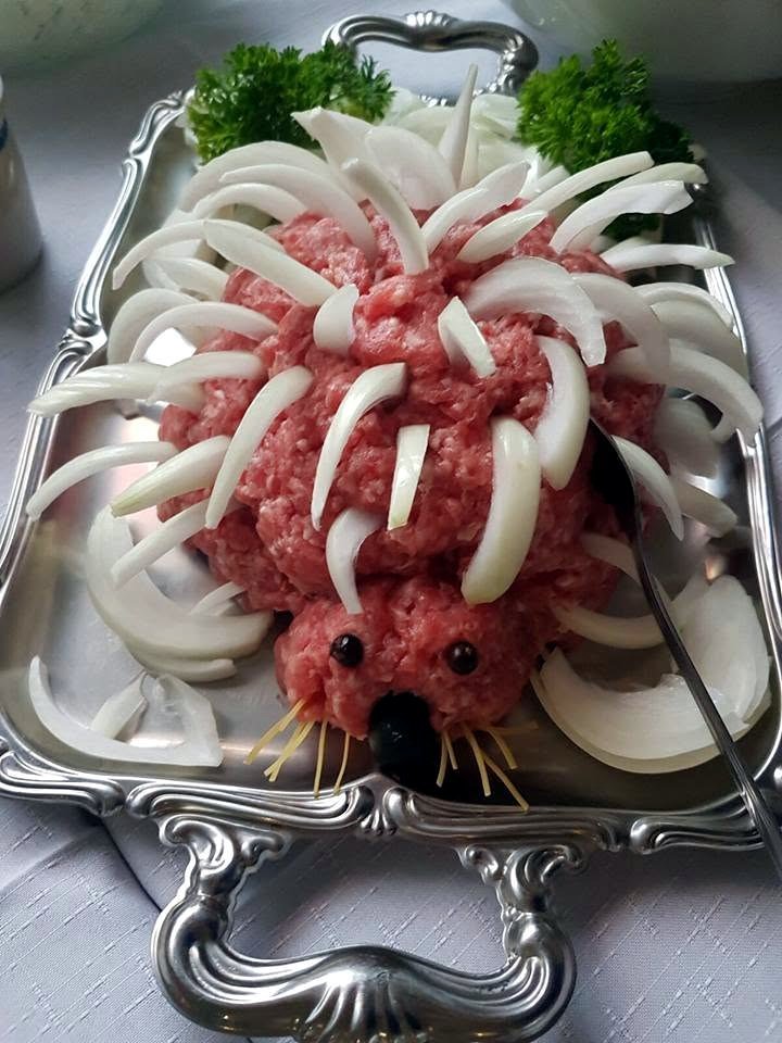Ein Mettigel mit Zwiebelstacheln auf einer silbernen Platte.