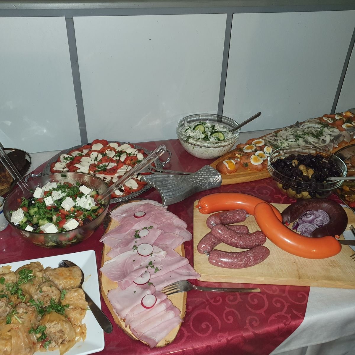 Salate, Tomate mit Mozzarella, Fleischwurst und Schinken auf dem Buffet.